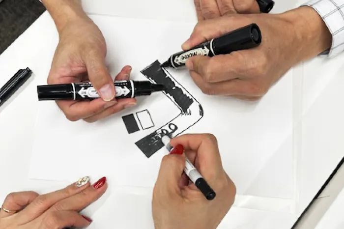 第一ビルディングの社員が手書きパーパスの文字を描いている様子